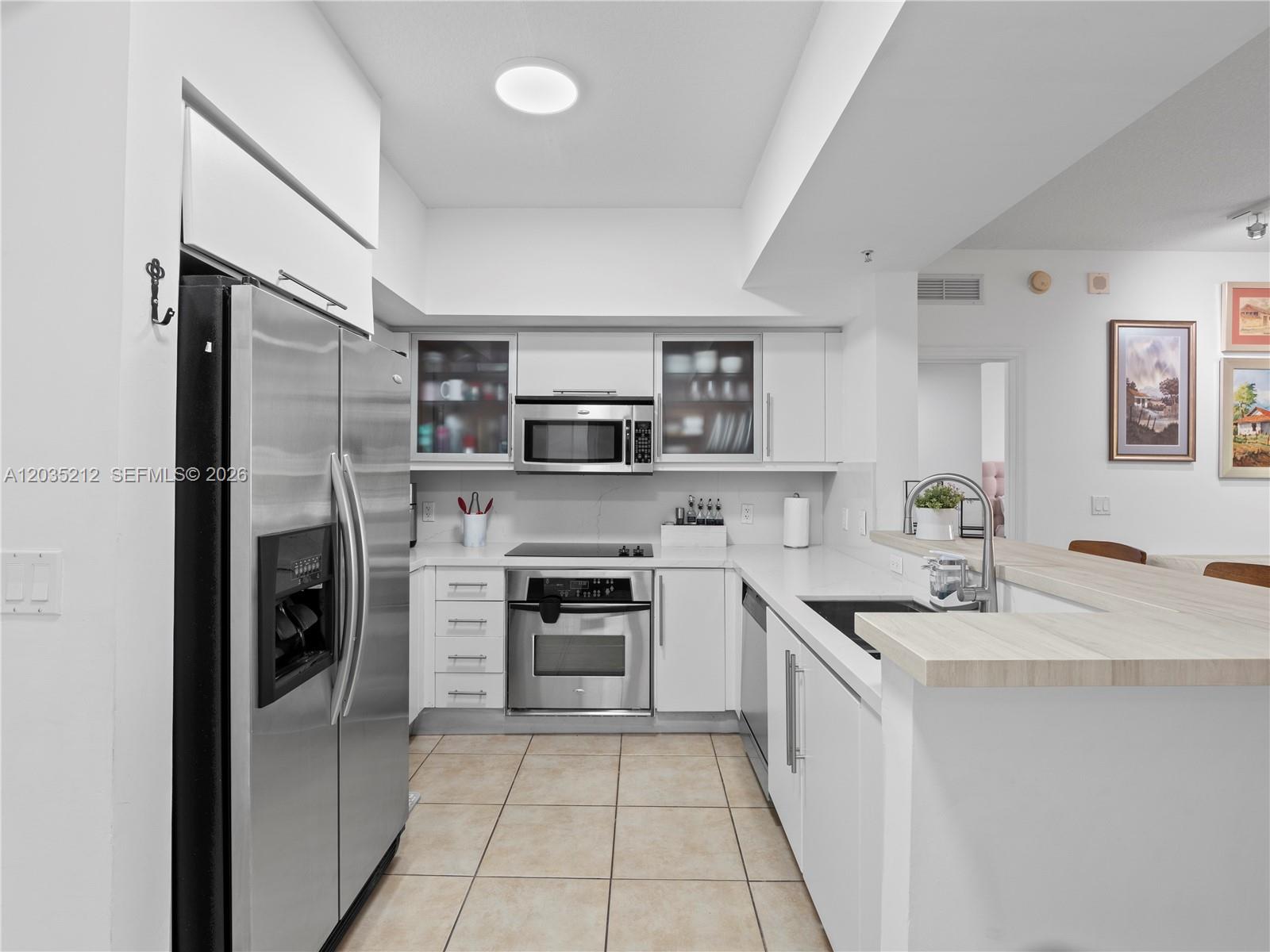 888 Douglas Road, Unit 302 Coral Gables, FL 33134 - Photo 4 of 51 KITCHEN WITH STAINLESS STEEL APPLIANCES, QUARTZ AND PORCELAIN FINISHES