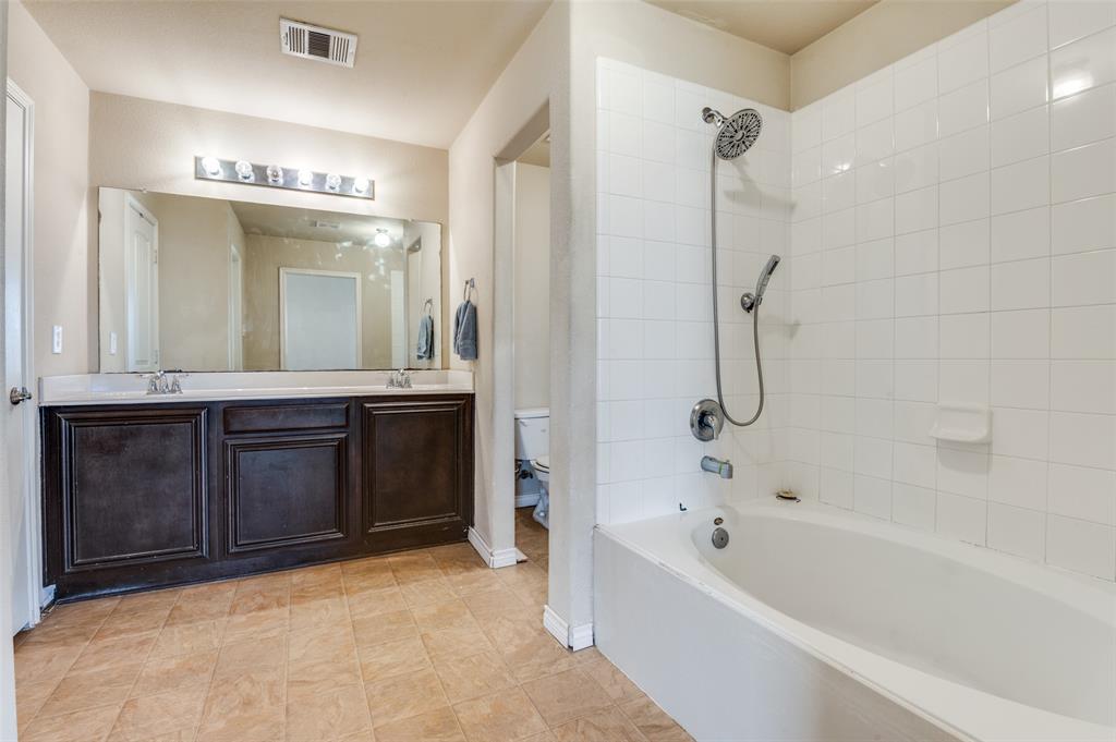 4040 Golden Rod Drive Forney, TX 75126 - Photo 21 of 25 a bathroom with a bathtub a double vanity sink and mirror