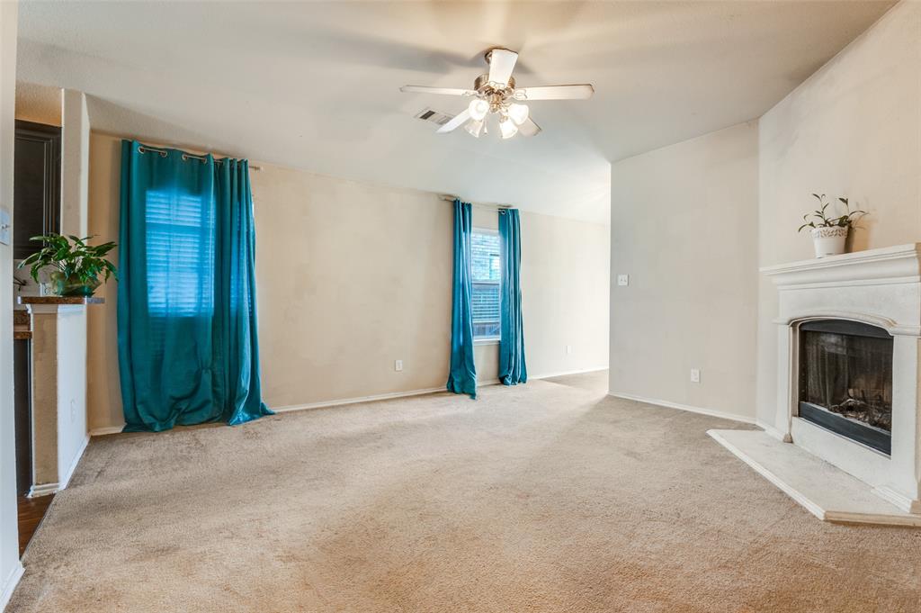 4040 Golden Rod Drive Forney, TX 75126 - Photo 7 of 25 a view of a livingroom with a fireplace a chandelier fan and windows