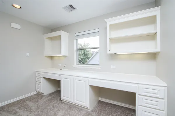 a view of an empty room with wooden floor fireplace and a window
