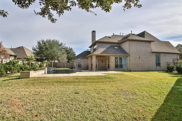 a view of pool with outdoor seating and house in the background