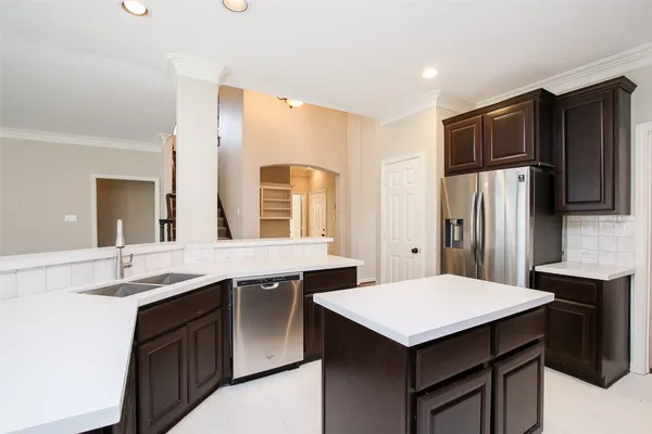 an empty room with wooden floor chandelier and windows