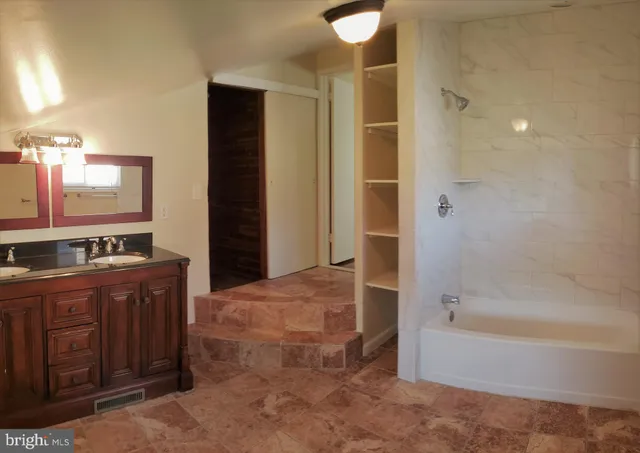 a bathroom with a bathtub sink and mirror