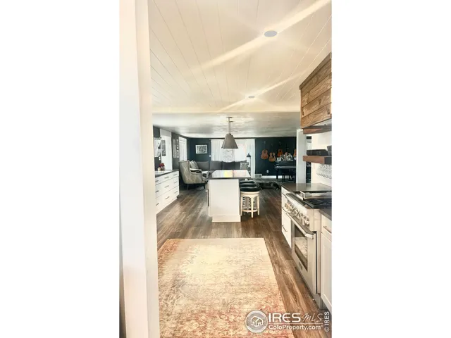 a large white kitchen with sink and stainless steel appliances