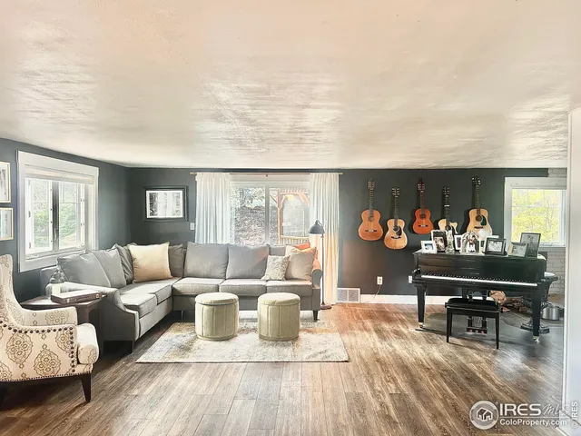 a living room with furniture a dining table and a piano table with wooden floor