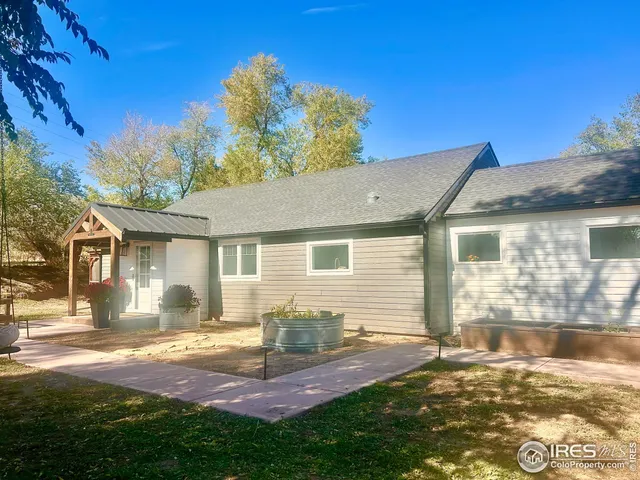 a view of a yard in front of a house with large windows
