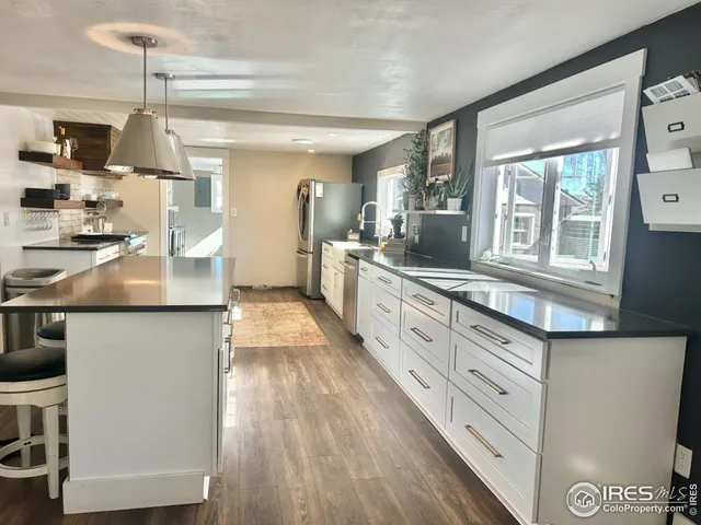 a large kitchen with stainless steel appliances granite countertop a stove and a sink