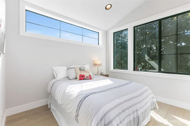 a bedroom with a bed and a large window