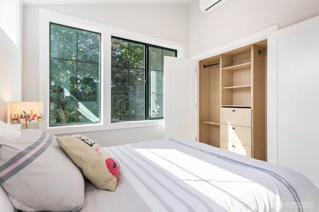 a bedroom with a bed and a large window