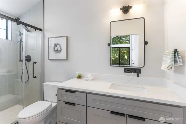 a bathroom with a sink toilet vanity and shower