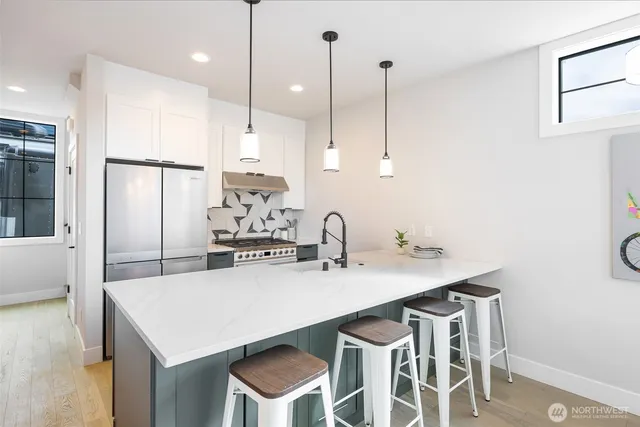 a kitchen with a sink a center island and stainless steel appliances