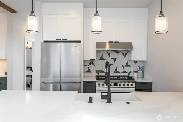 a kitchen with stainless steel appliances kitchen island granite countertop a refrigerator and a stove