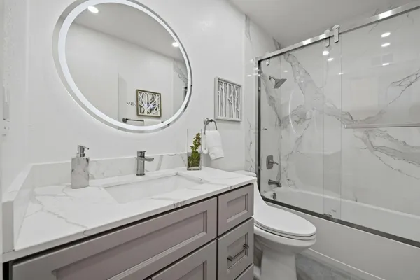 a bathroom with a sink a toilet and shower