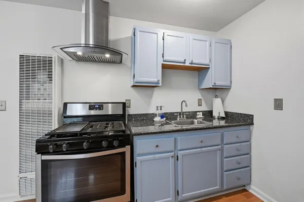 a kitchen with granite countertop stainless steel appliances and white cabinets
