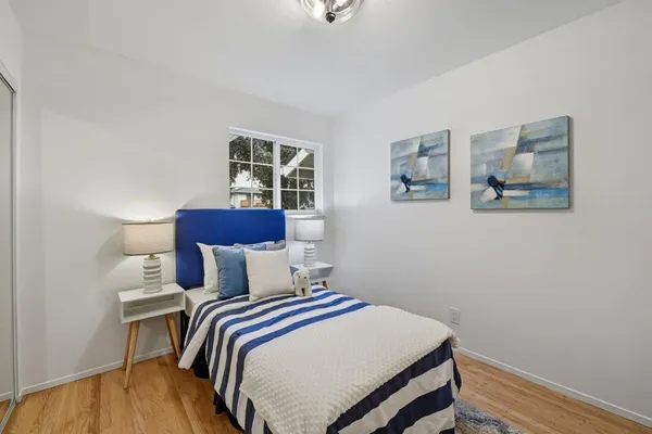 a bedroom with a bed and wooden floor