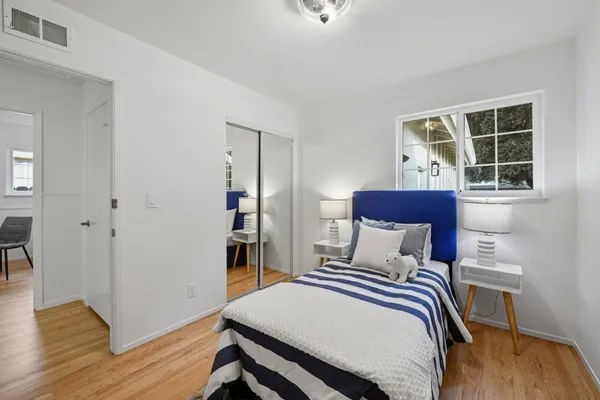 a bedroom with a bed and wooden floor