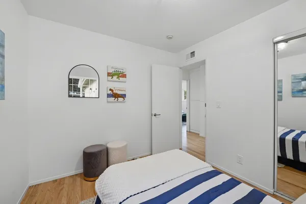 a bedroom with a bed and a painting on the wall