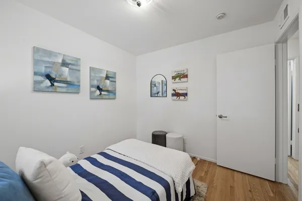 a bedroom with a bed and painting on the wall