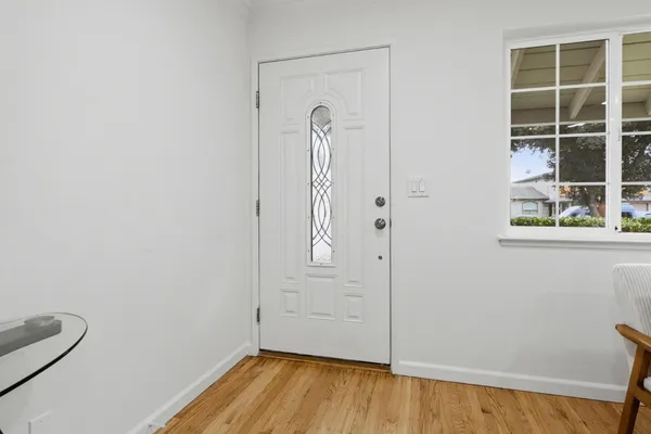 a view of empty room with wooden floor and window