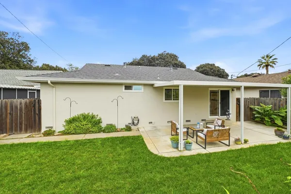 a view of a chair and table in backyard of the house