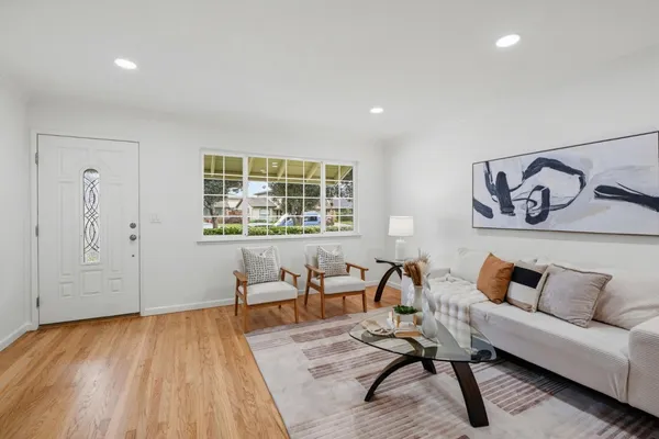 a living room with furniture and a wooden floor
