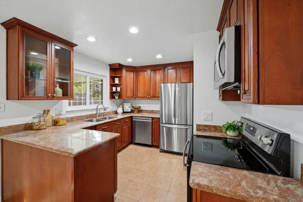 a kitchen with stainless steel appliances granite countertop a sink stove and refrigerator