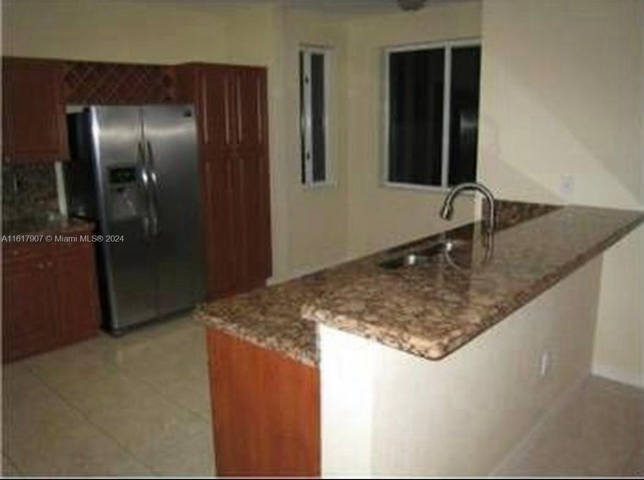 15259 Southwest 23rd Lane Miami, FL 33185 - Photo 5 of 10 a kitchen with a granite countertop sink and refrigerator