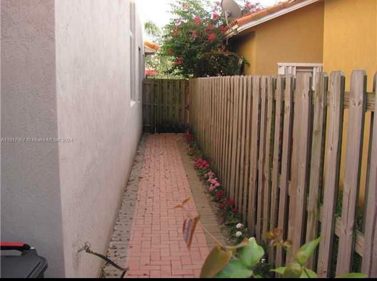 15259 Southwest 23rd Lane Miami, FL 33185 - Photo 8 of 10 a view of a pathway gate with wooden fence