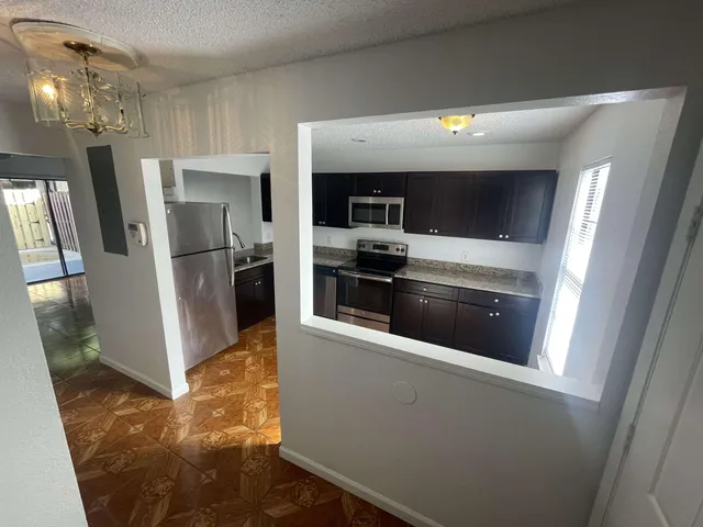 a view of a kitchen with a sink and refrigerator
