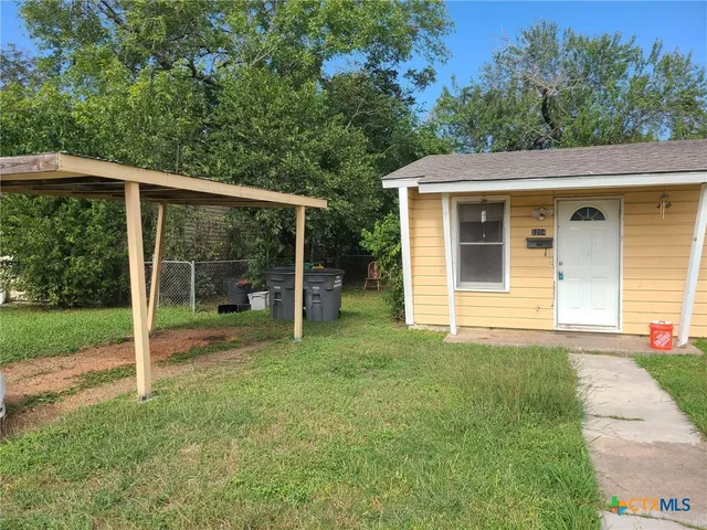 a view of a house with backyard and porch
