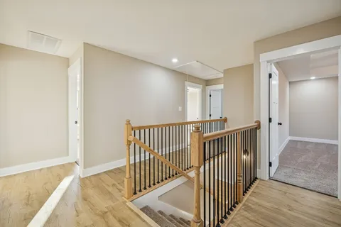 a view of a hallway with wooden floor and entryway