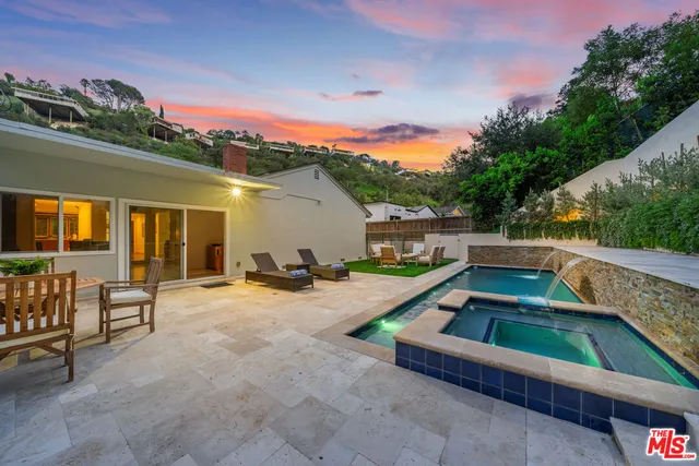 a backyard of a house with table and chairs