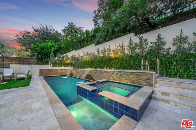 a view of a swimming pool with a patio and a yard
