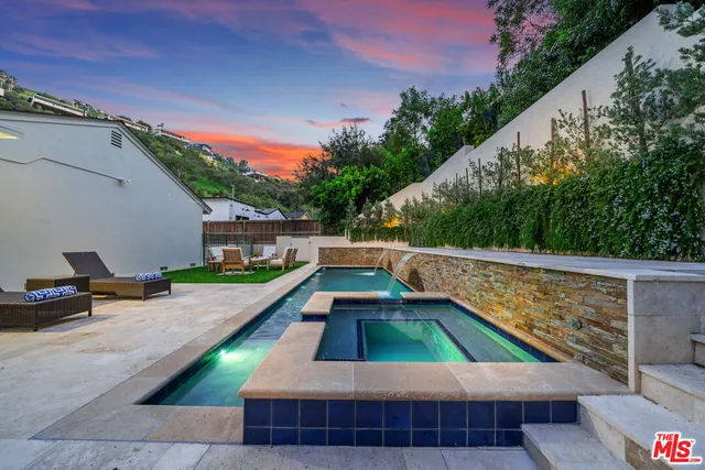 a front view of white house with a garden