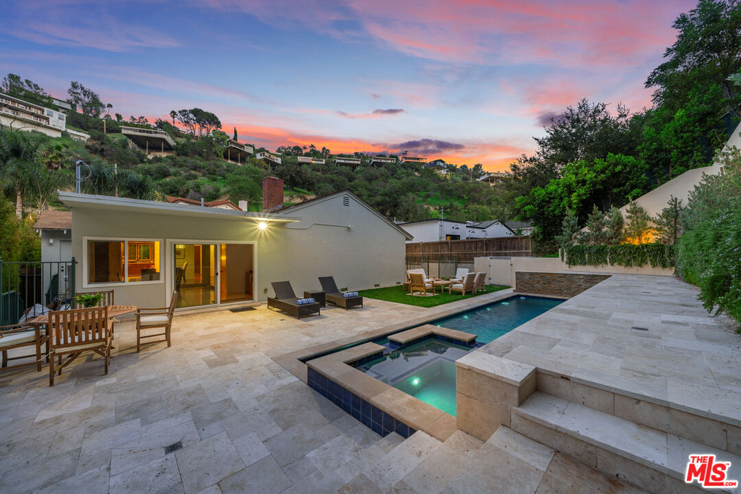 3771 Longview Valley Road Sherman Oaks, CA 91423 - Photo 15 of 75 a view of a backyard with couches table and chairs under an umbrella