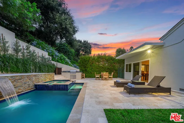 a large kitchen with stainless steel appliances a large counter top a stove and a refrigerator