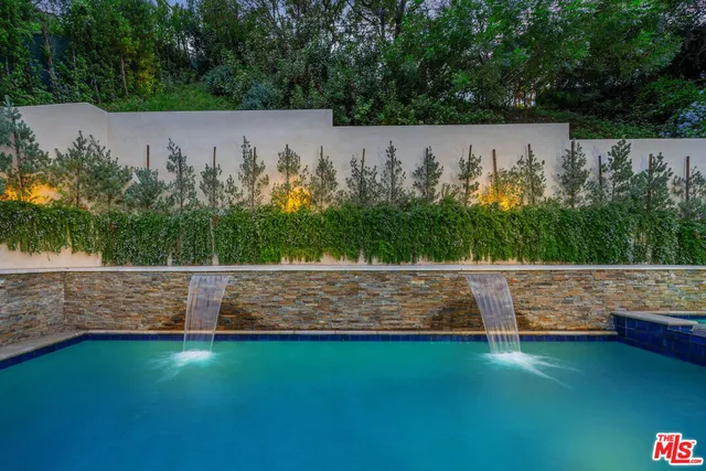 a kitchen with stainless steel appliances granite countertop a sink a stove and wooden cabinets