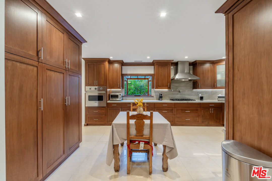 3771 Longview Valley Road Sherman Oaks, CA 91423 - Photo 32 of 75 a kitchen with granite countertop wooden cabinets a counter top space and stainless steel appliances
