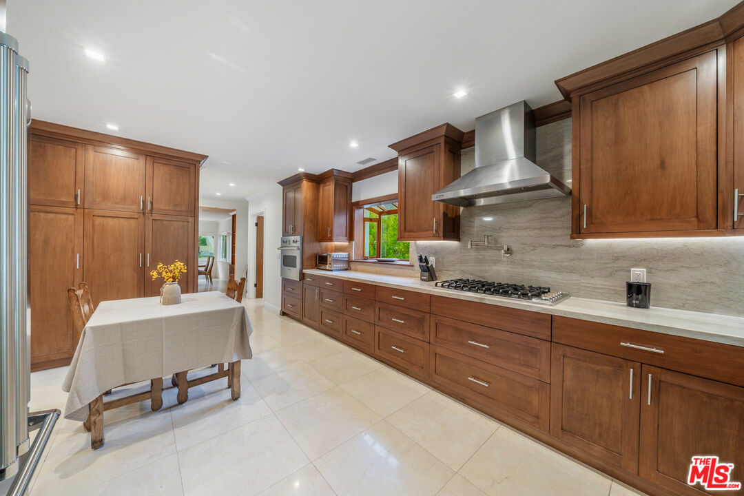 3771 Longview Valley Road Sherman Oaks, CA 91423 - Photo 40 of 75 a large kitchen with stainless steel appliances a large counter top a stove and a refrigerator