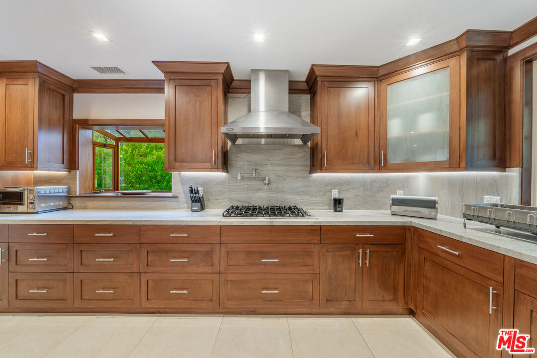 3771 Longview Valley Road Sherman Oaks, CA 91423 - Photo 41 of 75 a kitchen with stainless steel appliances granite countertop a sink a stove and wooden cabinets