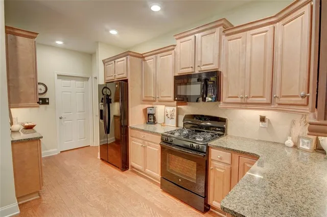 a kitchen with stainless steel appliances granite countertop a refrigerator stove and sink