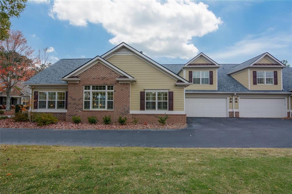 910 Brook Knoll Lane Cumming, GA 30041 - Photo 3 of 36 a front view of a house with a garden and yard