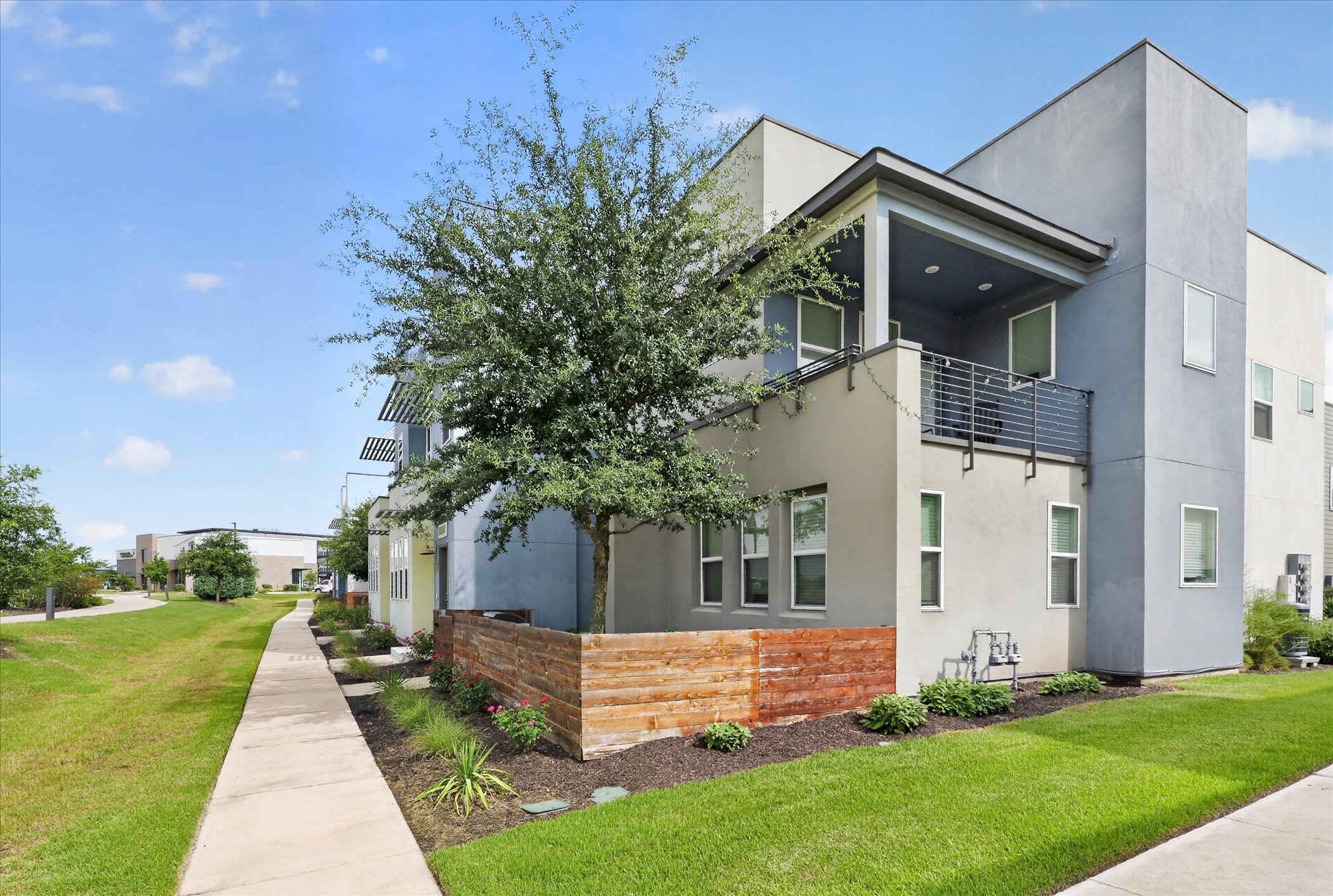 9015 Cattle Baron Path, Unit 1102 Austin, TX 78747 - Photo 3 of 25 Modern townhome exterior with a private balcony and contemporary landscaping.