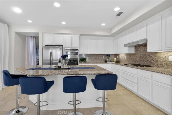 a kitchen with stainless steel appliances granite countertop a sink and a stove