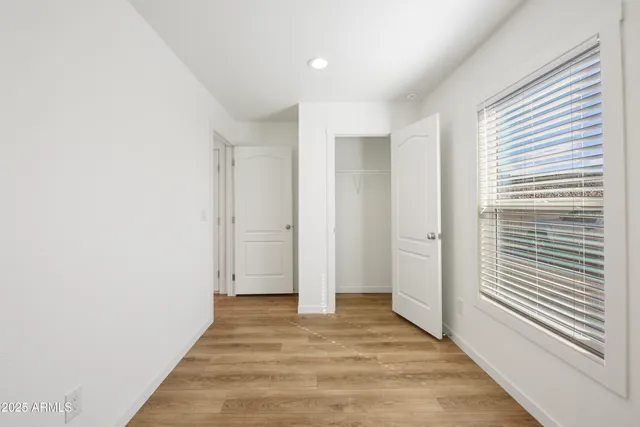 a view of a room with wooden floor and a window