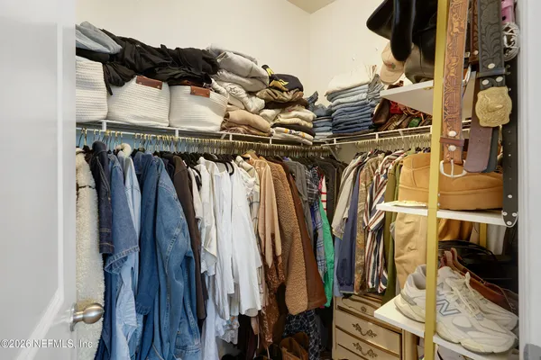 a view of walk in closet with clothes and shoes