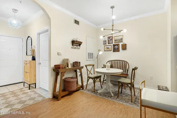 a living room with furniture a dining table and a chandelier
