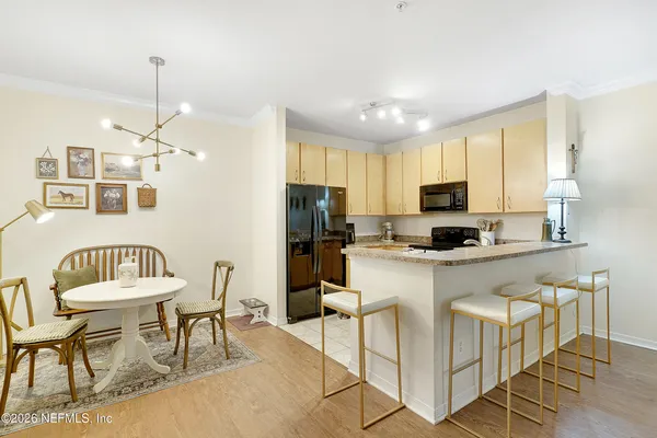 a kitchen with stainless steel appliances kitchen island granite countertop a dining table chairs microwave and sink