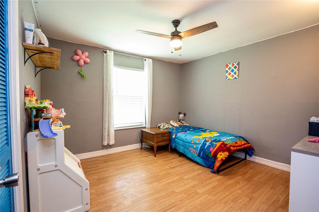 817 South Old Temple Road Lorena, TX 76655 - Photo 11 of 17 a bedroom with a bed and a chandelier