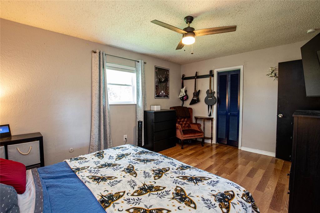 817 South Old Temple Road Lorena, TX 76655 - Photo 7 of 17 a bedroom with a bed and a dresser with wooden floor